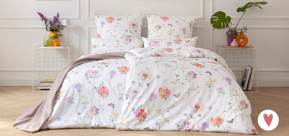 Bettwäsche Aluna mit Blumenmuster in mehreren Farben auf hellem Grund auf Bett im Schlafzimmer